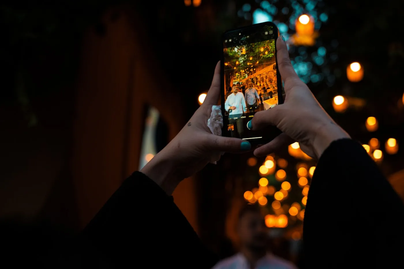 Hands holding an iPhone in portrait orientation, recording a Reel — casual, mobile-native context